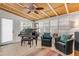 Sunroom features a piano, seating area, and wood ceiling at 501 S Peninsula Ave, New Smyrna Beach, FL 32169