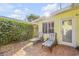 Relaxing backyard patio with lounge chairs and privacy hedge at 501 S Peninsula Ave, New Smyrna Beach, FL 32169