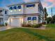 Two-story house with blue shutters and a paver driveway at 224 Condict Dr, New Smyrna Beach, FL 32169