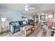 Living room with teal sofa and view into dining area and kitchen at 3801 S Atlantic Ave # 307, New Smyrna Beach, FL 32169