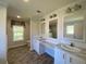 Double vanity bathroom with marble countertops and large mirrors at 689 Eagle Watch Rd, Oak Hill, FL 32759