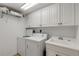 Well-lit laundry room, complete with washer, dryer, and cabinets at 5300 S Atlantic Ave # 15-601, New Smyrna Beach, FL 32169