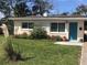 Charming Ranch style home with teal door and landscaped yard at 113 Neptune Dr, Edgewater, FL 32132