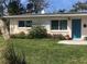 Charming Ranch style home with teal door and landscaped yard at 113 Neptune Dr, Edgewater, FL 32132