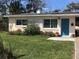Charming Ranch style home with teal door and landscaped yard at 113 Neptune Dr, Edgewater, FL 32132
