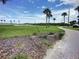 Brick pathway meanders through a grassy park with palm trees at 113 Neptune Dr, Edgewater, FL 32132