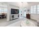 Bright living room with a large TV, light grey furniture, and hardwood floors at 456 Lime Ave, Daytona Beach, FL 32124