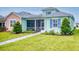Charming two-story house with light teal and peach siding, screened porch, and landscaped yard at 456 Lime Ave, Daytona Beach, FL 32124