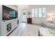 Bright living room with a large TV, light grey furniture, and hardwood floors at 456 Lime Ave, Daytona Beach, FL 32124