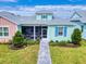 Charming two-story home with light teal and pink exterior, screened porch, and landscaped yard at 456 Lime Ave, Daytona Beach, FL 32124