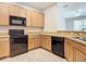 Modern kitchen features wood cabinets, black appliances, and light-colored countertops at 679 Mount Olympus Blvd, New Smyrna Beach, FL 32168