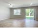 Bright living room with sliding glass doors leading to a patio and wood-look floors at 679 Mount Olympus Blvd, New Smyrna Beach, FL 32168