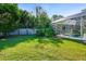Large backyard with a grassy lawn and screened pool at 510 Sun Lake Dr, Port Orange, FL 32127