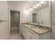 Double vanity bathroom with granite countertops and large mirror at 2266 Hawks Cove Cir, New Smyrna Beach, FL 32168