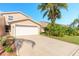 Tan townhome with white garage door and palm trees at 2266 Hawks Cove Cir, New Smyrna Beach, FL 32168