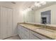 Modern bathroom with granite countertops, double sinks, and a large mirror at 2266 Hawks Cove Cir, New Smyrna Beach, FL 32168