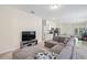 Spacious living room features a sectional sofa, large TV and open concept view to kitchen at 2352 Litchfield Loop, Deland, FL 32720