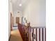 Upstairs hallway with wood railing and access to bedrooms at 2471 Jenscot Rd, Saint Cloud, FL 34771