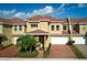 Two-story townhome with red tile roof, two-car garage, and brick driveway at 3608 Romea Cir, New Smyrna Beach, FL 32168