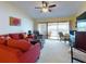 Living room with red sofa, balcony access and water view at 452 Bouchelle Dr # 303, New Smyrna Beach, FL 32169