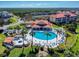 Aerial view of community pool, spa, clubhouse, and surrounding landscape at 452 Bouchelle Dr # 303, New Smyrna Beach, FL 32169