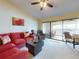 Relaxing living room with red sectional sofa and access to a private balcony at 452 Bouchelle Dr # 303, New Smyrna Beach, FL 32169