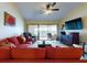 Comfortable living area featuring a red sectional sofa and a large TV at 452 Bouchelle Dr # 303, New Smyrna Beach, FL 32169