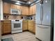 Modern kitchen with white appliances and wood cabinets at 5207 S Atlantic Ave # 0622, New Smyrna Beach, FL 32169