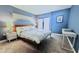 Spacious bedroom with a blue wall, king-size bed, and a work desk at 5207 S Atlantic Ave # 0622, New Smyrna Beach, FL 32169