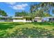 Back exterior view of a ranch-style house with a large yard at 1527 Magnolia St, New Smyrna Beach, FL 32168