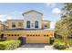 Front view of a two-story house with a two-car garage and well-manicured lawn at 2681 Sweet Magnolia Pl, Oviedo, FL 32765