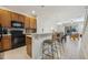 Open kitchen features a breakfast bar, dark wood cabinets, and black appliances at 2681 Sweet Magnolia Pl, Oviedo, FL 32765