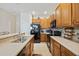 Modern kitchen with dark wood cabinets, black appliances, and ample counter space at 2681 Sweet Magnolia Pl, Oviedo, FL 32765
