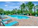 Community pool with plenty of lounge chairs and umbrellas at 2681 Sweet Magnolia Pl, Oviedo, FL 32765