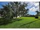 Large grassy backyard with a tree and home view at 3218 Royal Palm Dr, Edgewater, FL 32141