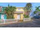 Bright yellow townhome with white picket fence and tropical landscaping at 4017 Saxon Dr, New Smyrna Beach, FL 32169