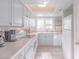 Efficient galley-style kitchen with light-grey cabinets and white countertops at 4017 Saxon Dr, New Smyrna Beach, FL 32169