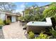 Relax in the backyard hot tub, surrounded by lush landscaping and a brick patio at 624 S Pine St, New Smyrna Beach, FL 32169