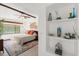 Main bedroom with a ceiling fan, built-in shelves, and a cozy sitting area at 624 S Pine St, New Smyrna Beach, FL 32169