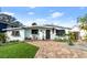 Charming mid-century home with landscaped yard and brick driveway at 624 S Pine St, New Smyrna Beach, FL 32169