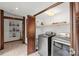 Laundry room with washer, dryer, and built-in wooden cabinets at 624 S Pine St, New Smyrna Beach, FL 32169