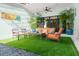 Relaxing patio with seating area, artificial turf, and tropical plants at 624 S Pine St, New Smyrna Beach, FL 32169