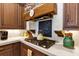 Kitchen detail showing cooktop, custom range hood, and unique backsplash at 1032 Early Ave, Winter Park, FL 32789