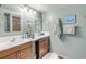 Bathroom featuring double vanity, large mirror, and soft green walls at 130 Indian Creek Rd, Oak Hill, FL 32759