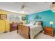 Tranquil bedroom with teal accent wall, wooden furniture, and comfy bedding at 130 Indian Creek Rd, Oak Hill, FL 32759