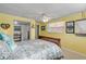 Bright yellow bedroom with ceiling fan, wooden headboard, and nautical decor at 130 Indian Creek Rd, Oak Hill, FL 32759