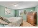 Serene green bedroom with wooden dresser, ceiling fan, and natural light at 130 Indian Creek Rd, Oak Hill, FL 32759