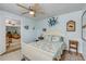 Quaint bedroom with coastal decor, a ceiling fan, and an open doorway leading to another room at 130 Indian Creek Rd, Oak Hill, FL 32759