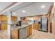 Kitchen with island, wood cabinets, stainless steel appliances, and tile backsplash at 130 Indian Creek Rd, Oak Hill, FL 32759