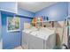 Compact laundry room equipped with washer, dryer, and storage shelves at 130 Indian Creek Rd, Oak Hill, FL 32759